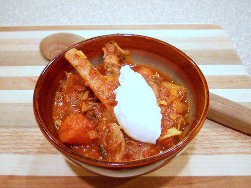 An earthenware bolw of Yaga Stew with a dollop of sour cream on top. 