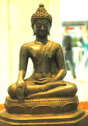 Burmese, Cambodian, or Thai statue of Lord Buddha, seated, in the Earth touching mudra, with the gold flame of wisdom on his head (and ushnisha), monk's robe, exhibit, San Francisco International Airport, San Francisco, California, USA by Wonderlane