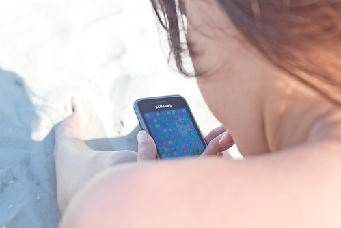 Playing mobile games on the beach by vamapaull, on Flickr