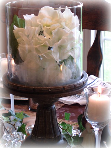 Two white lovebirds on crystal candleholders flank the middle hydrangea 