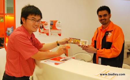 A delighted Ronald Felix Hardin receiving his complimentary RM50 'SoGood' KFC Meal Voucher with the purchase of an RM50 reload card from U Mobile