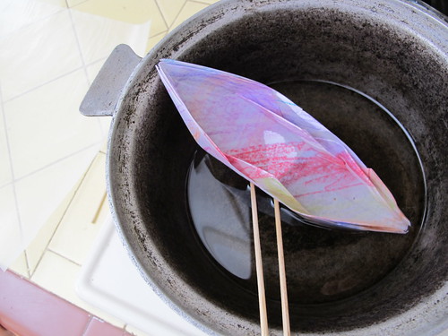 dipping an origami boat in wax