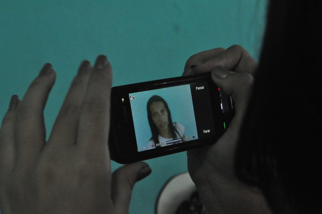 Photograph of a woman watching a video on a smart phone