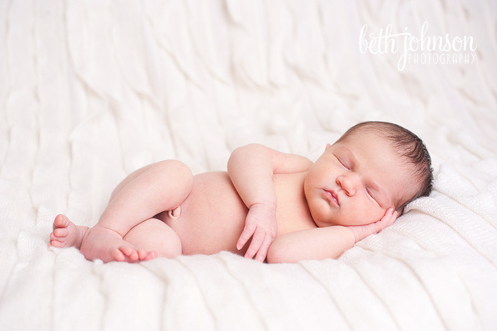 newborn baby photographer baby on white ruffled blanket