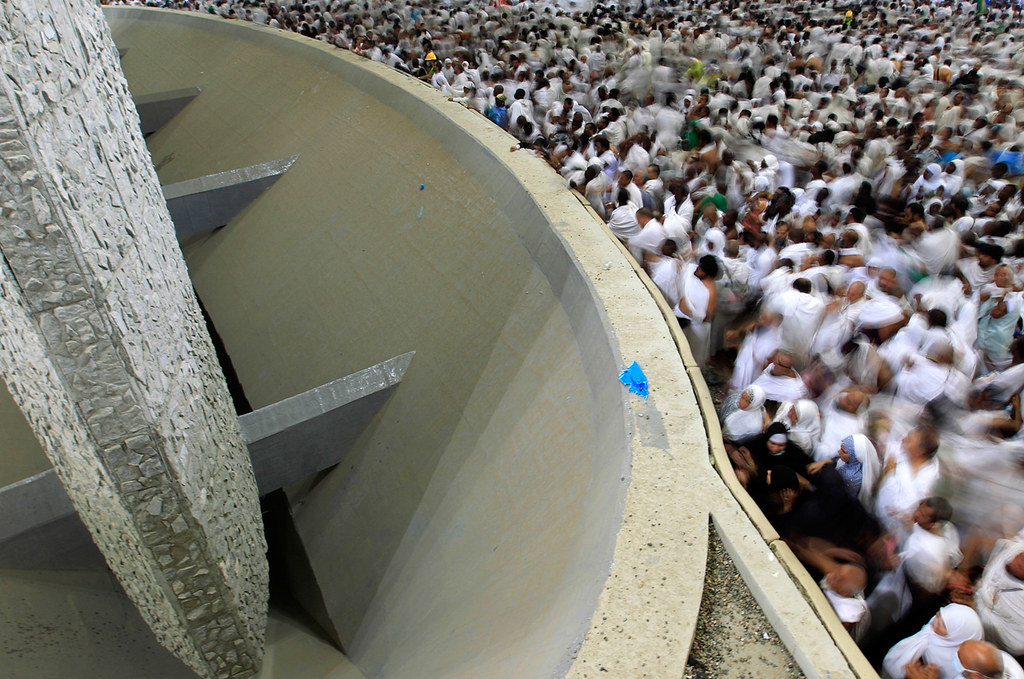 Muslim pilgrims cast stones at a pillar, symbolizing the stoning of Satan