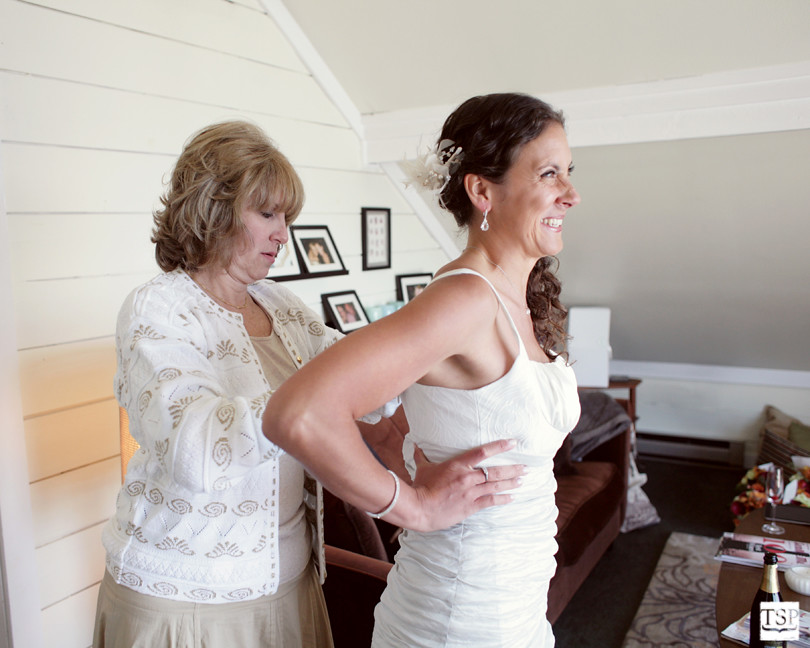 Mother of Bride Helping Bride into Dress
