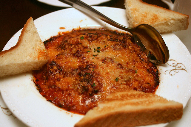 Scrambled egg gratin with tomato fondue, Paris ham, sauteed mushrooms and parmesan cheese, served with pain de mie toast