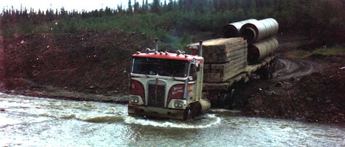 BC truck driver navigates a mountain creek with big tractor trailer 