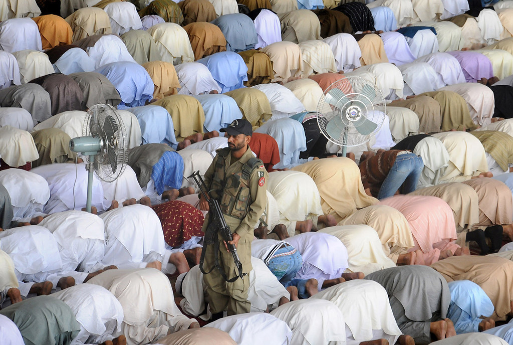 A Pakistani paramilitary soldier stands guard as Muslims offer Eid prayers 