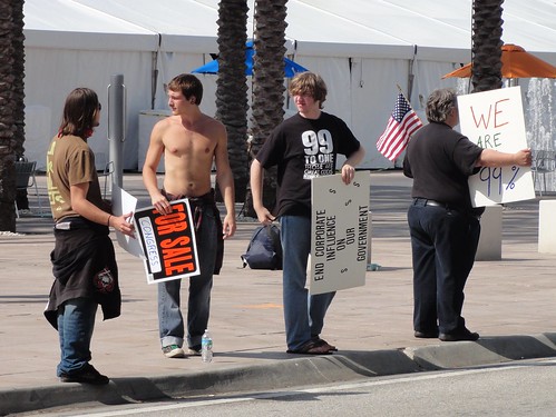 Shirtless man with "For Sale" sign