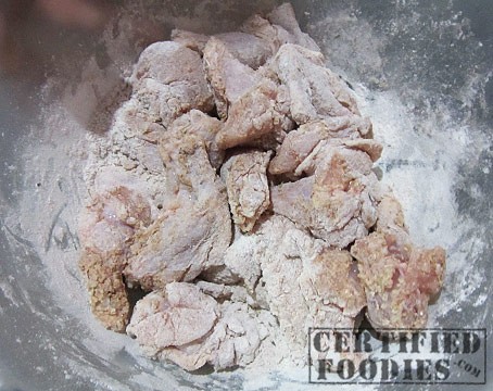 Evenly coat the chicken wings with the breading mix - CertifiedFoodies.com