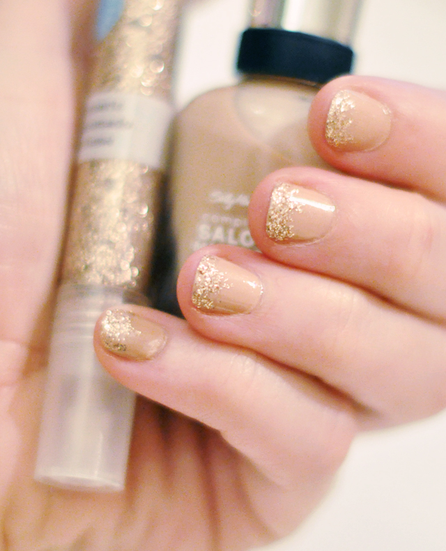 nude nail polish  with  gold glitter tips 