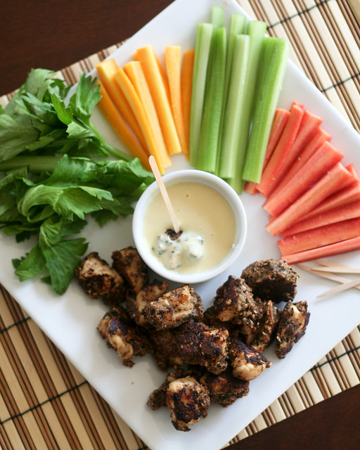 A plate of chicken popcorn with crudités and honey Dijon dipping sauce