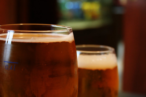 Two beer glasses lined up on a bar