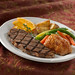 Grilled strip loin of beef (6 oz) served with a herb roasted boneless chicken breast (5 oz).