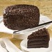 Four layers of moist chocolate cake filled with chocolate fudge icing, covered with dark chocolate curls.