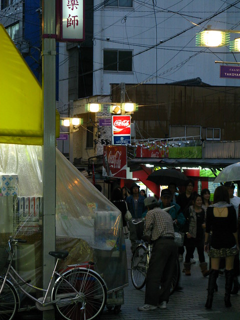 Photo of a drug store with its wares sheltered from the rain.
